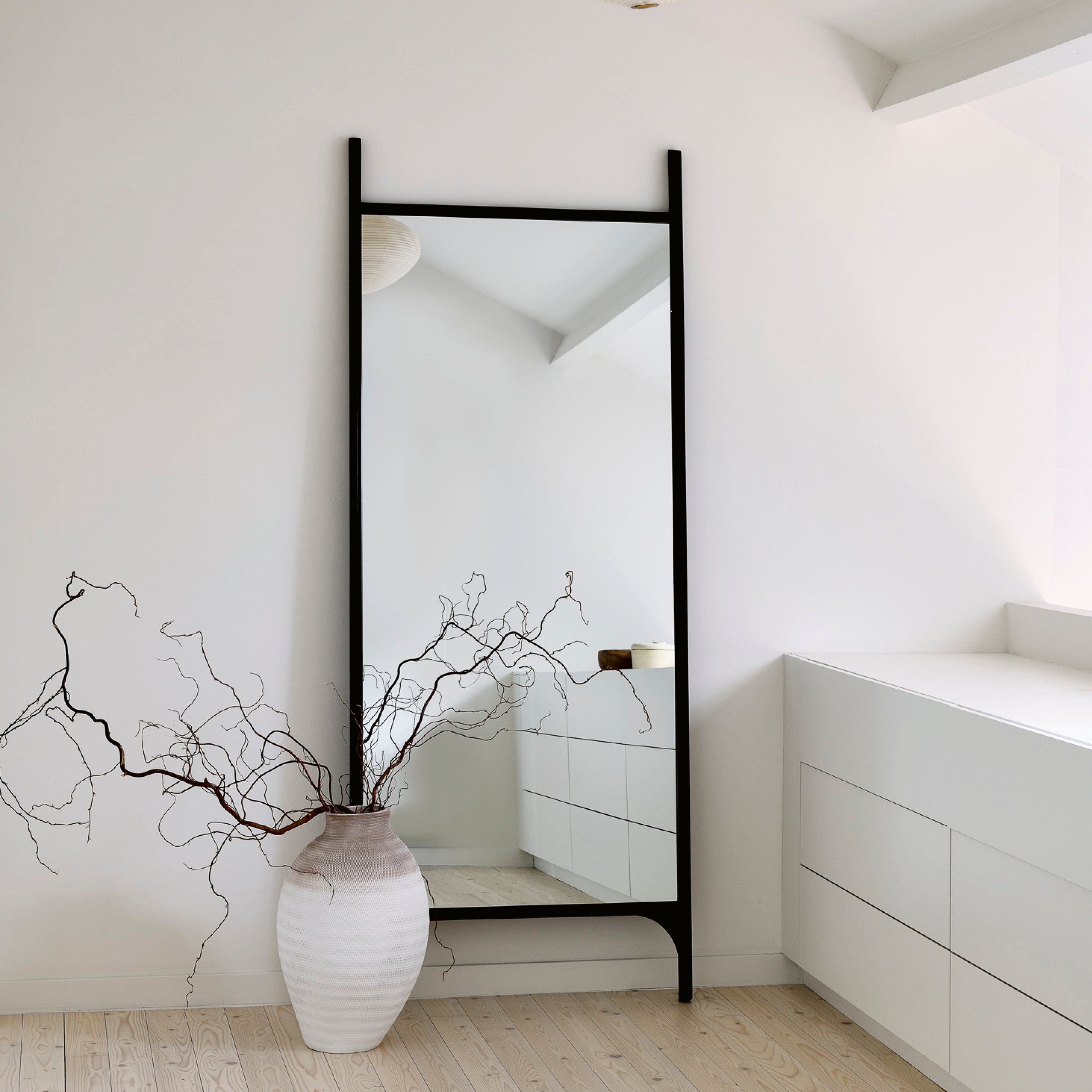 Design Spiegel als Standspiegel mit schwarzem Rahmen in hellem, modernem Wohnraum
