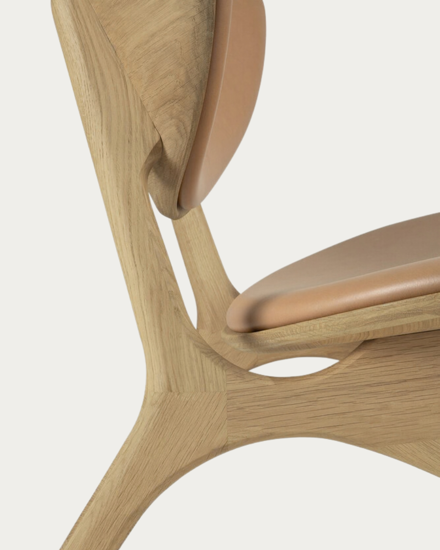 Close-up of the curved backrest of the EYE armchair with Sienna leather upholstery