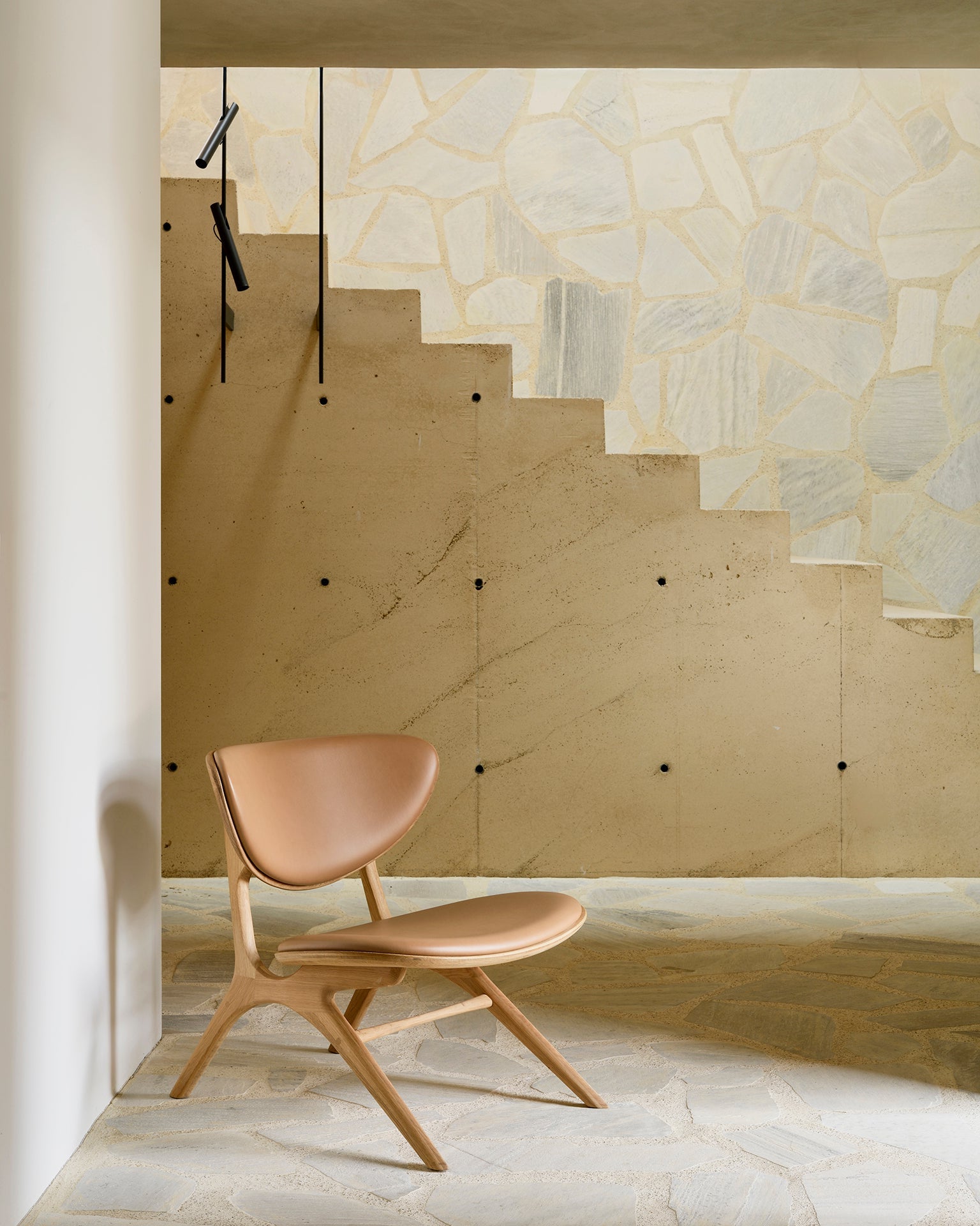 Ethnicraft EYE armchair with sienna leather upholstery in the reception area with wooden floor