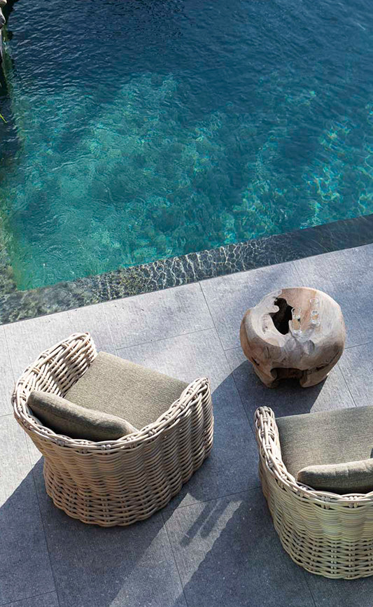 Zwei runde Outdoor-Sessel aus Naturgeflecht und organischem Beistelltisch aus Holz von der belgische DesignMarke Gommaire