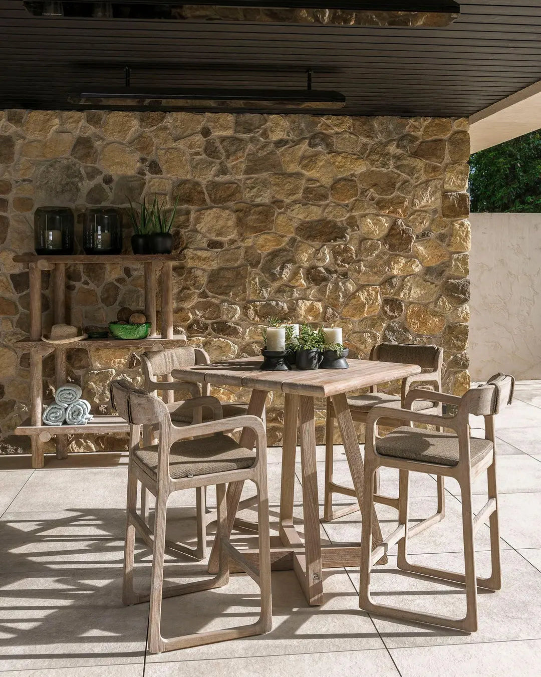SALLY bar chair by Gommaire with bar table on terrace - elegant teak bar chair with seat cushion in the modern outdoor bar area