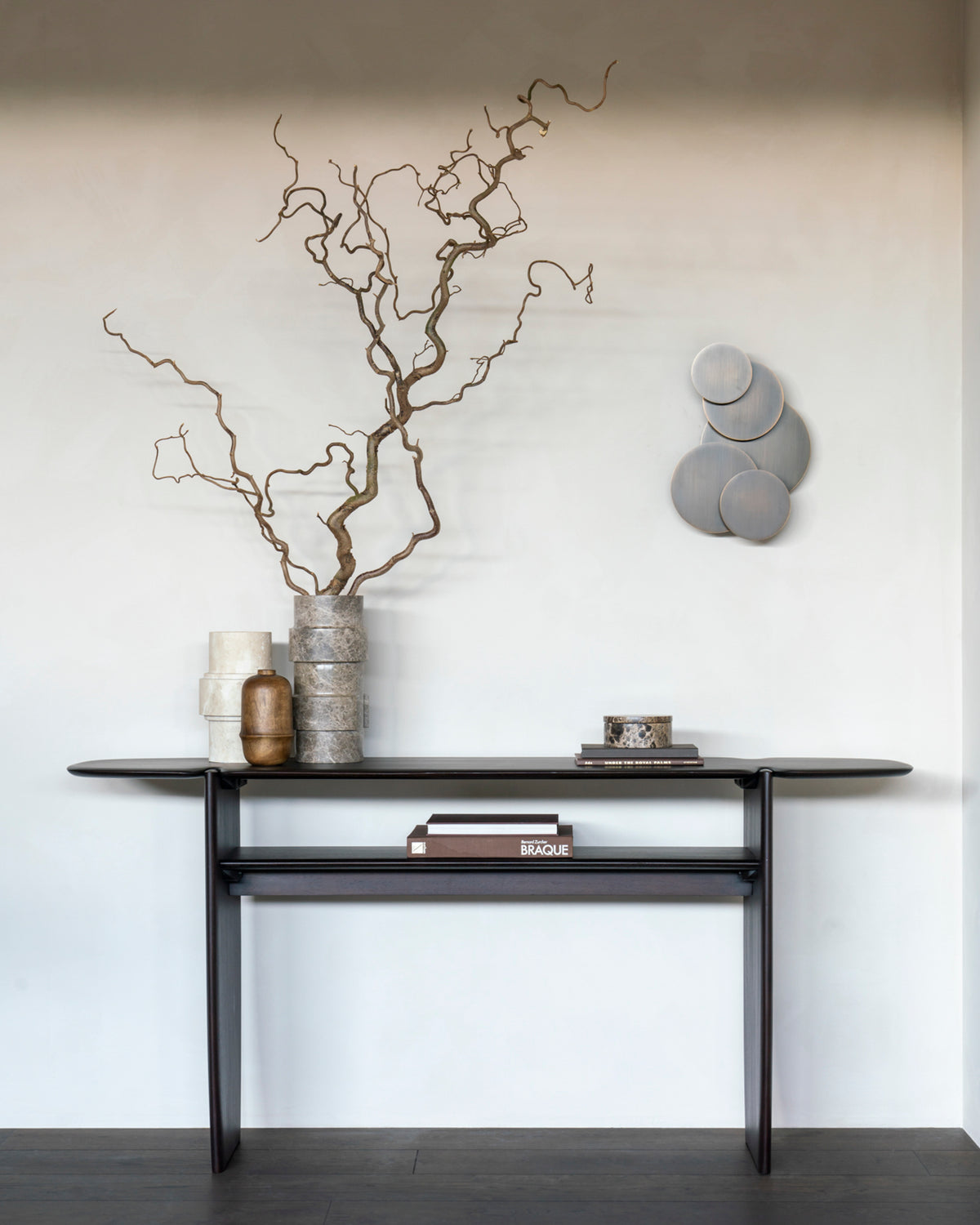 Ethnicraft PI console table, 160x75 cm, made of dark brown mahogany, with decorative objects in a bright entryway.
