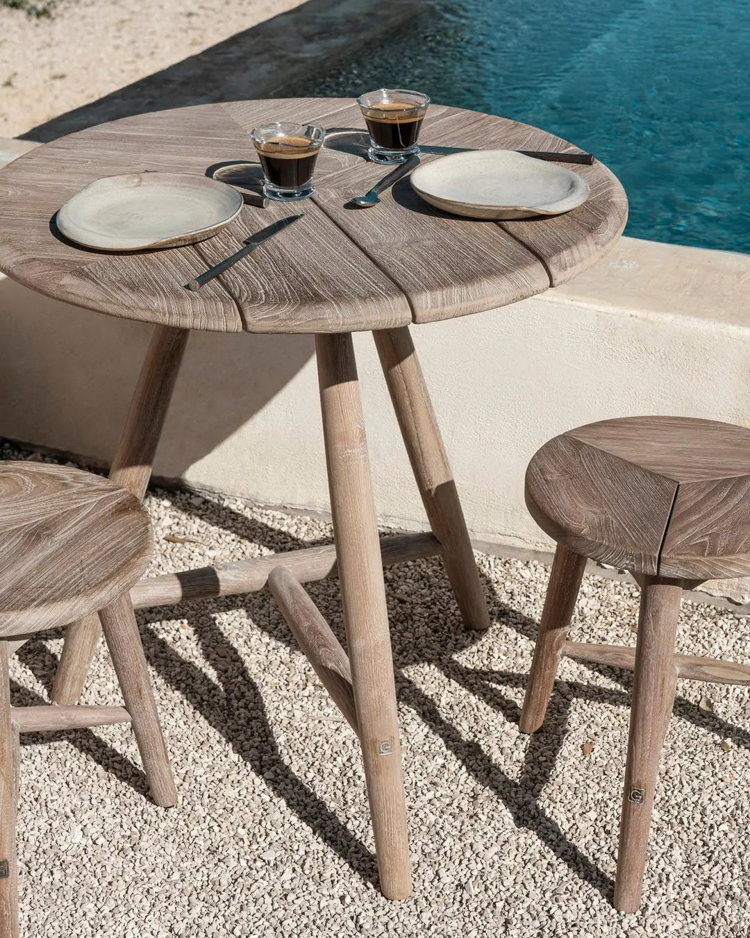 Close-up of the round teak of the Faye bistro table - naturally oiled, with a wood grain full of character