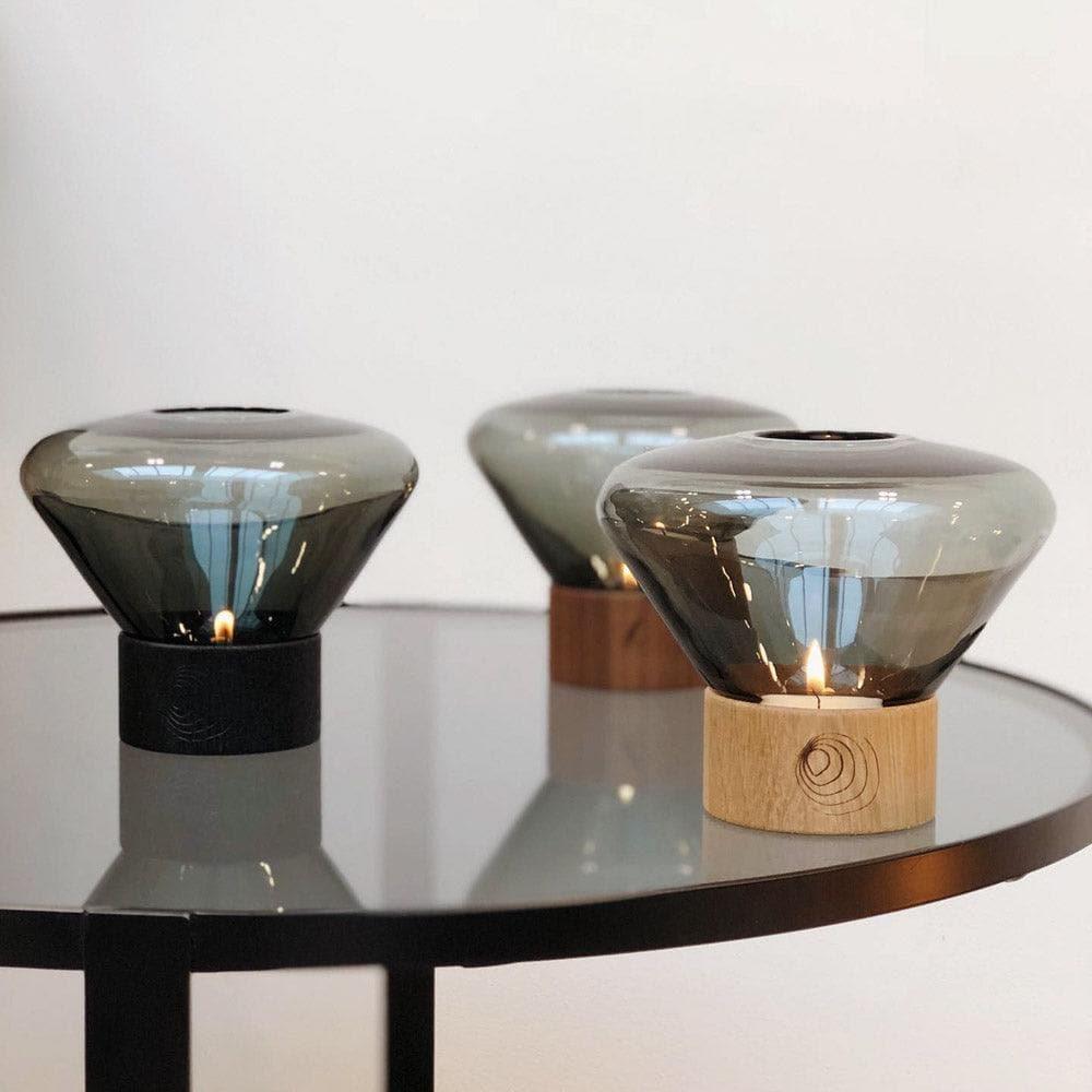 Drei Windlichter MUFFIN von Brokis auf einem Tisch – harmonisches Zusammenspiel unterschiedlicher Größen und Farben im stilvollen Arrangement