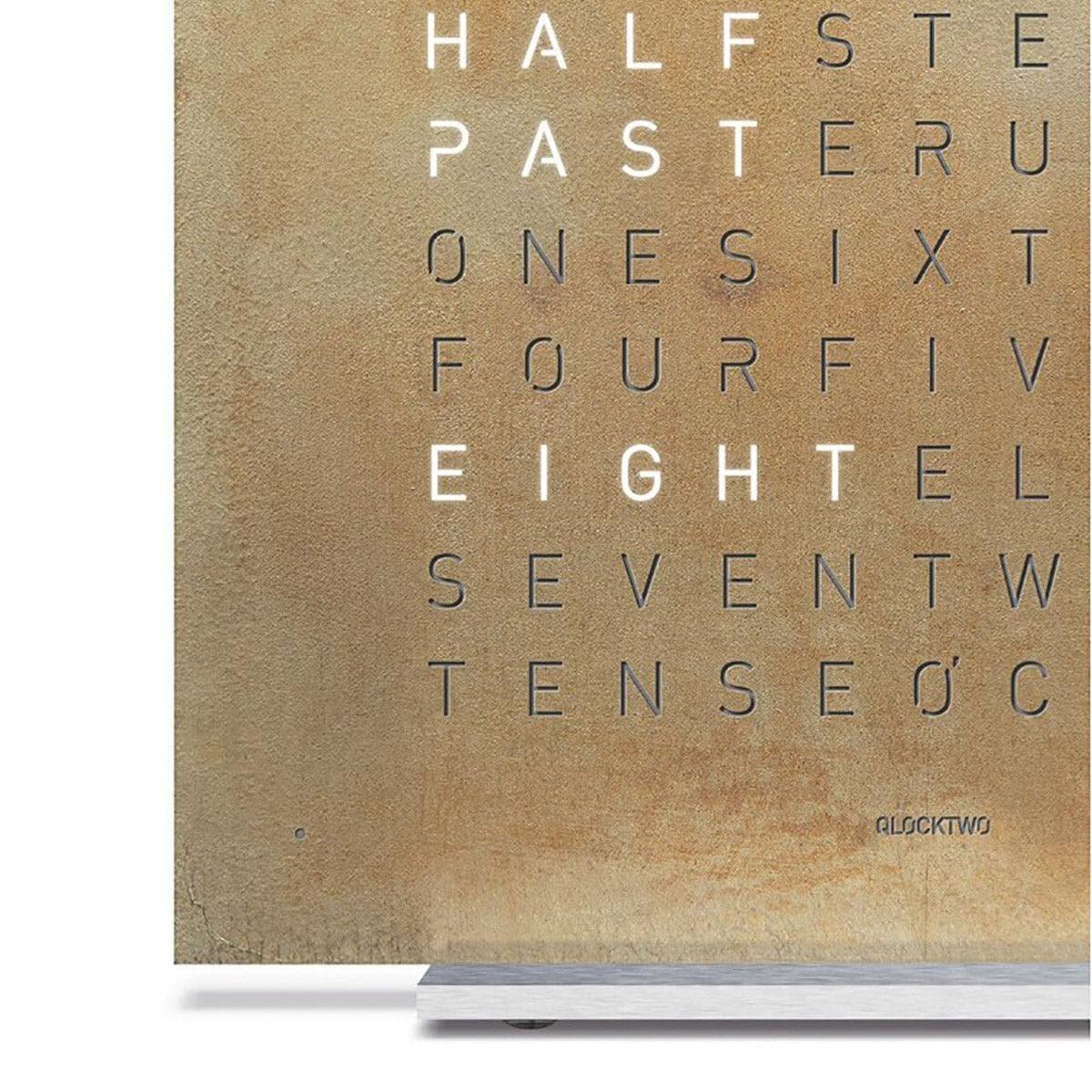 Detailaufnahme der QLOCKTWO EARTH 13.5 Silver & Gold – luxuriöse Oberfläche mit handveredeltem Gold- und Silberfinish, exklusive Uhr in Nahansicht