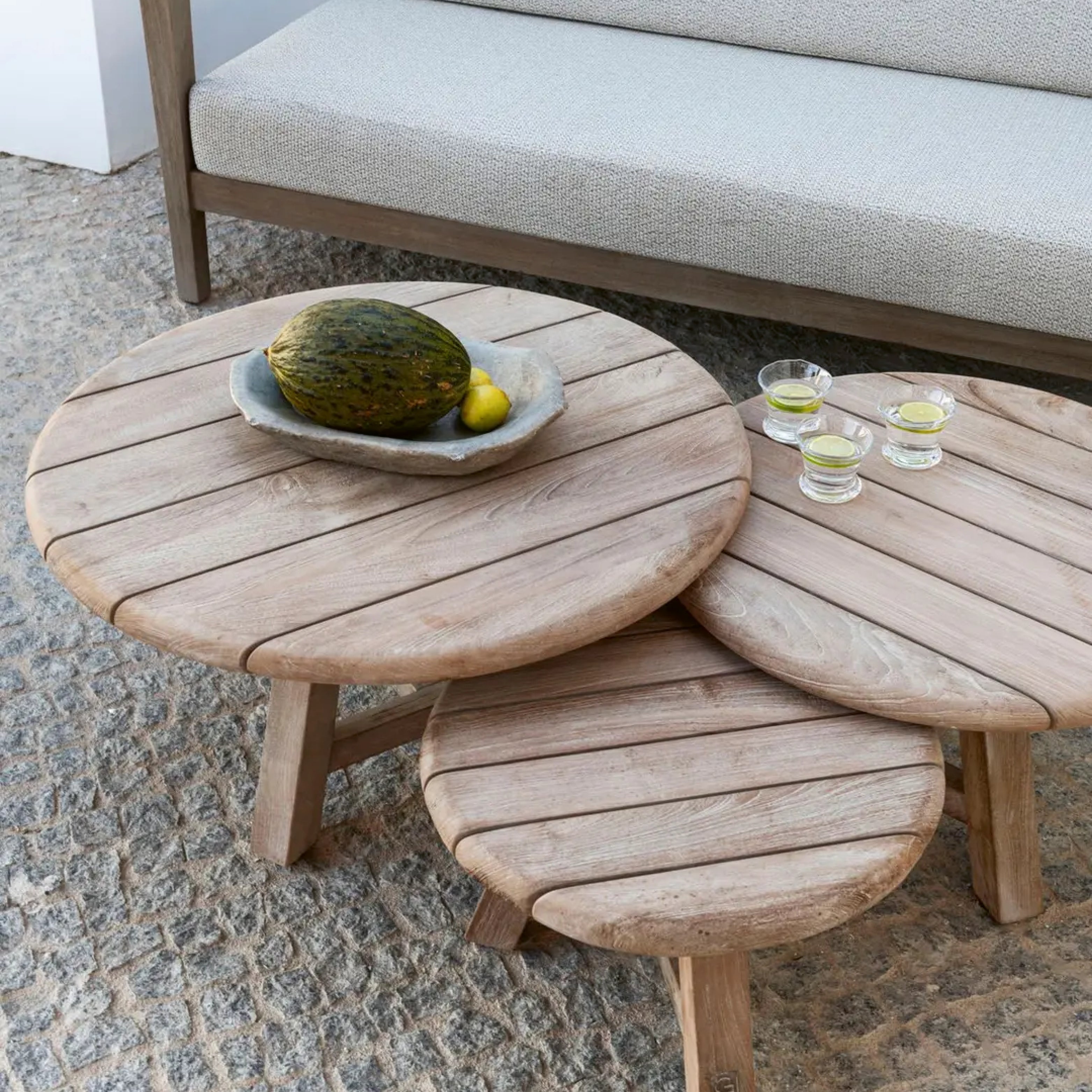 Outdoor Couchtisch aus recyceltem Teakholz von Gommaire auf moderner Terrasse mit Loungemöbeln und Glasvasen.