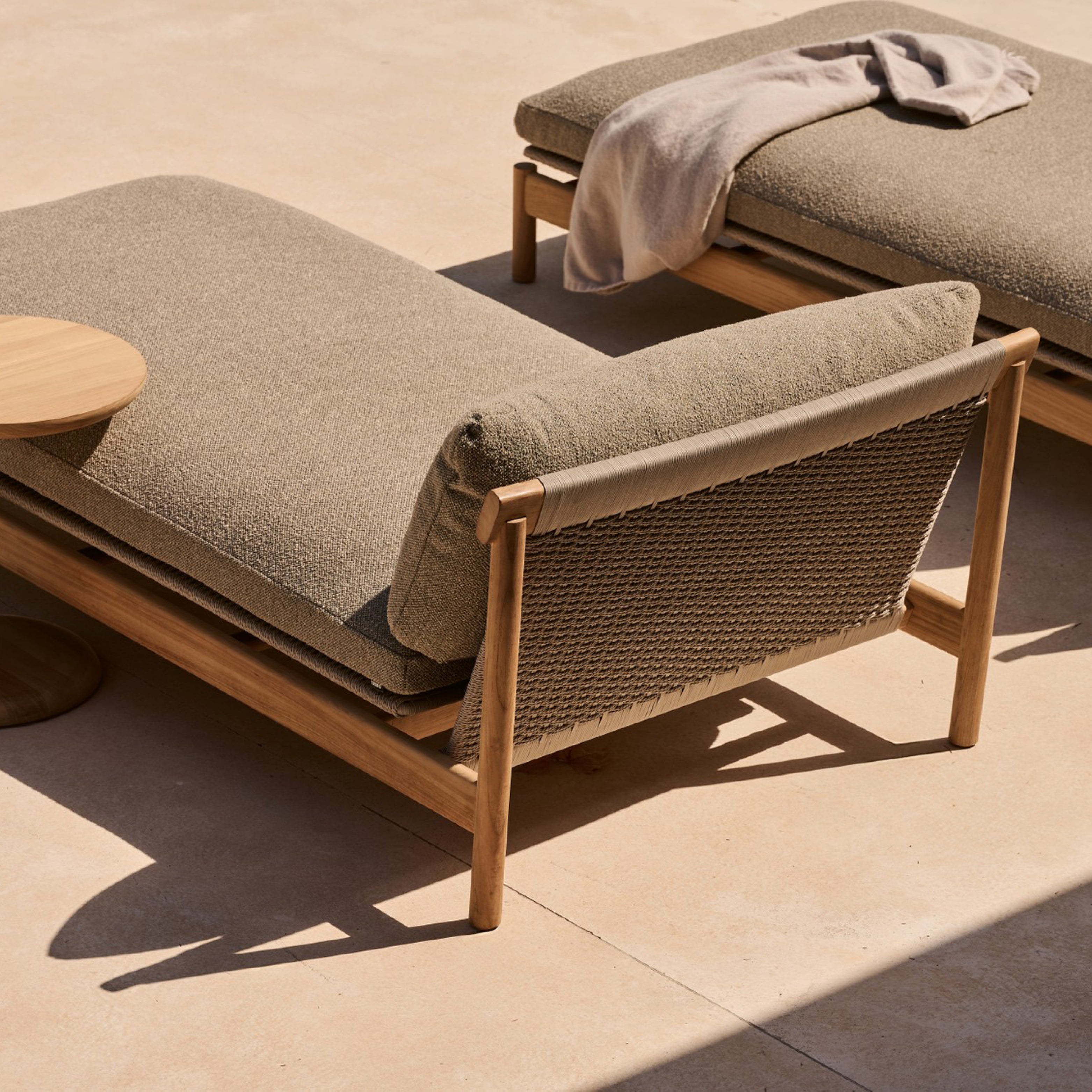 Outdoor-Daybed mit Teakrahmen und Rückenlehne aus Seilgeflecht – stilvolle Sonnenliege mit beigem Kissen auf warmer Terrasse