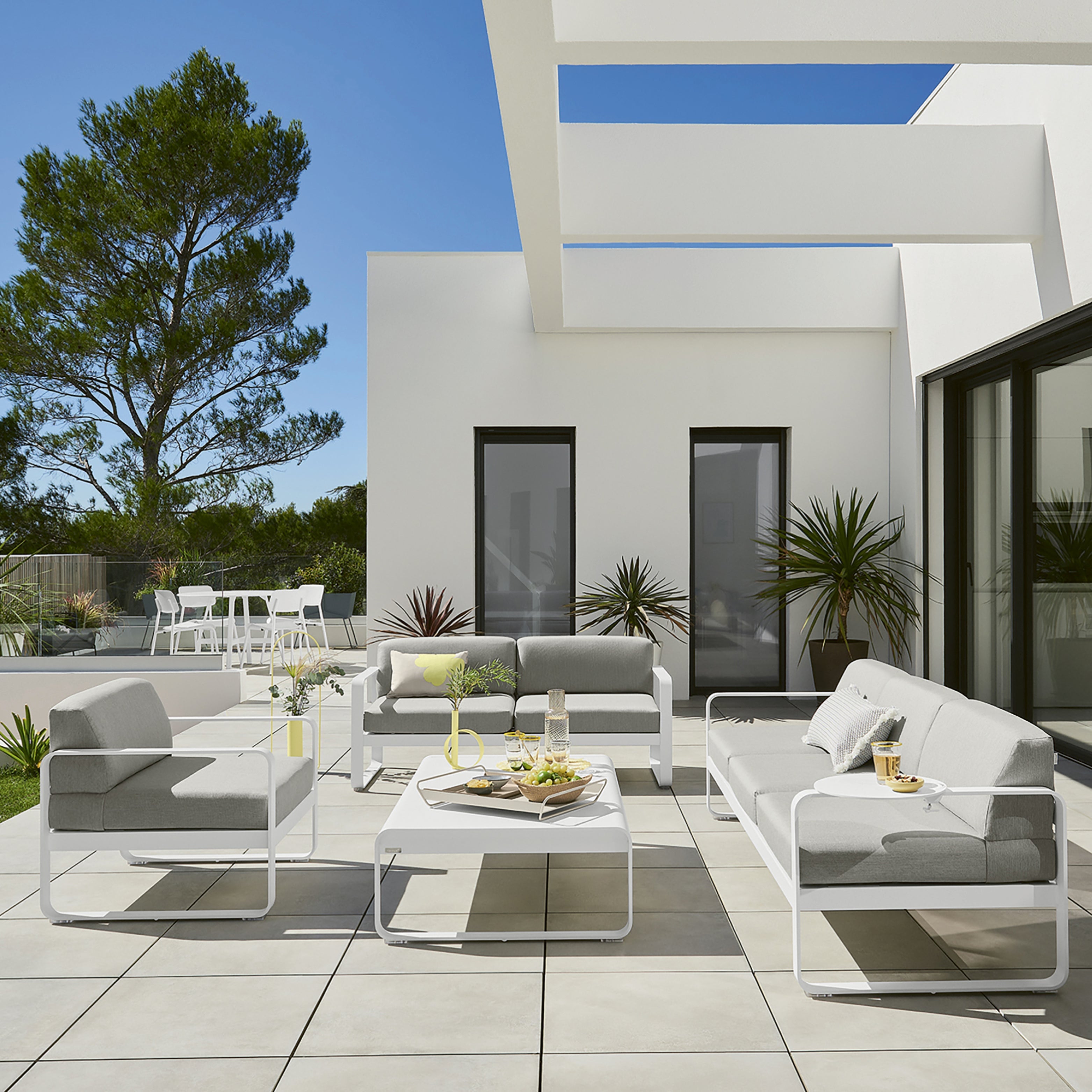 Bellevie Gartensofa-Set von Fermob auf moderner Terrasse – weiße Aluminiumrahmen mit hellgrauen Polstern im minimalistischen Outdoor-Stil