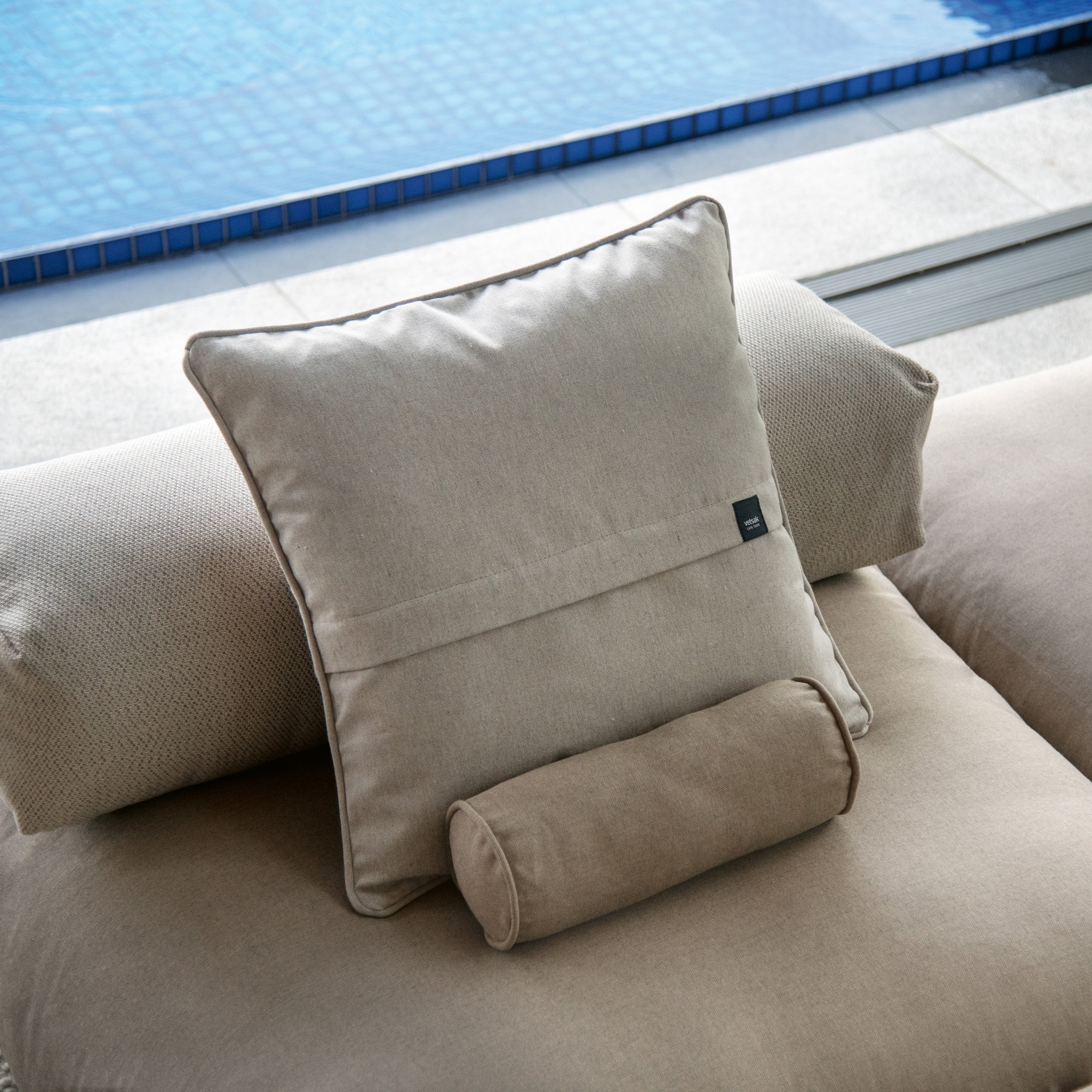Outdoor-Kissen von Vetsak in Beige auf Loungemodul am Pool
