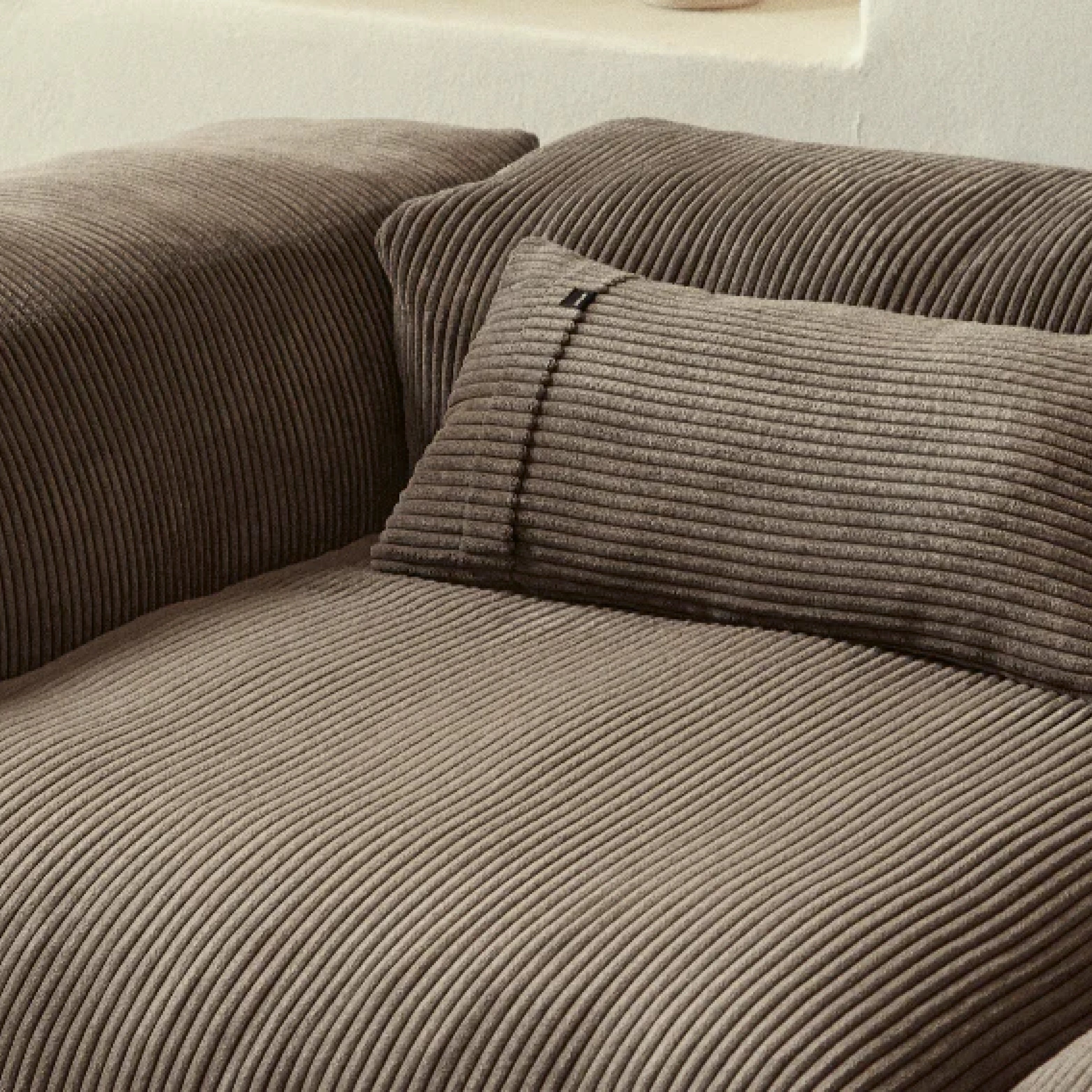 Nahaufnahme eines Vetsak Sofas mit braunem Cord Velours und Rückenkissen, ideal für gemütliche Wohnbereiche