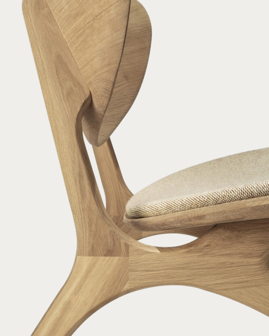 Close-up of the curved backrest of the EYE armchair with upholstery in Off White,