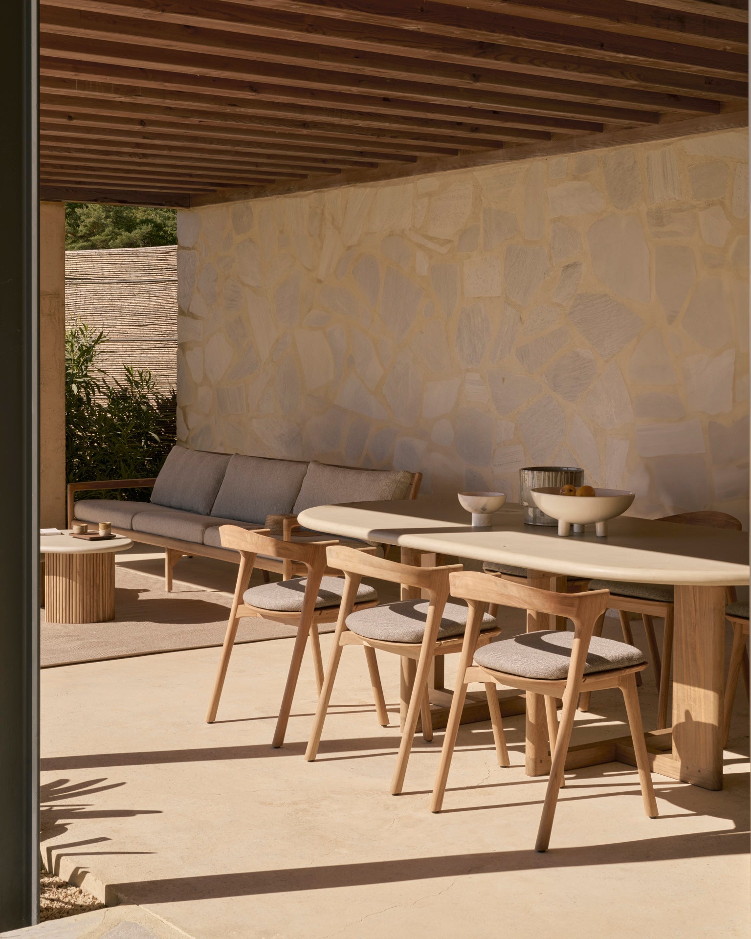 Ethnicraft TRESTLE outdoor dining table on a modern terrace with stone flooring