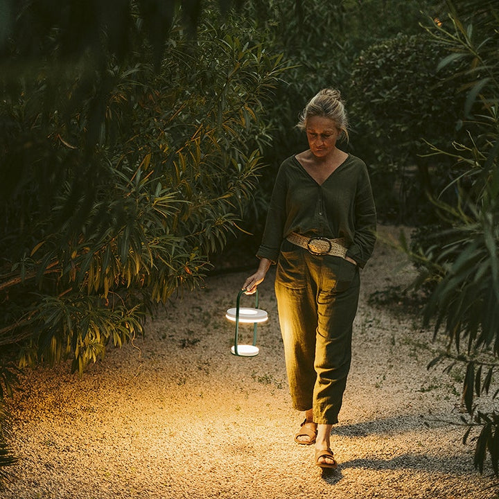 Ulli Lampe von Fermob in Zeder Grün mit Frau die spaziert | Homestorys