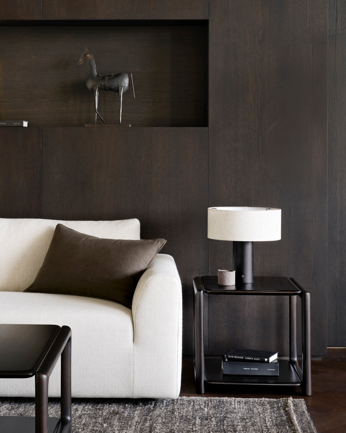 Ethnicraft EDA side table made of solid mahogany in Rose Brown, serving as a compact side table next to a modern sofa in the living room.