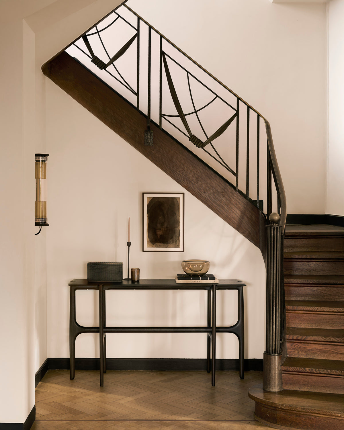 Ethnicraft PI console table, 130 x 75 cm, made of dark brown teak, with decorative objects in a bright entryway.