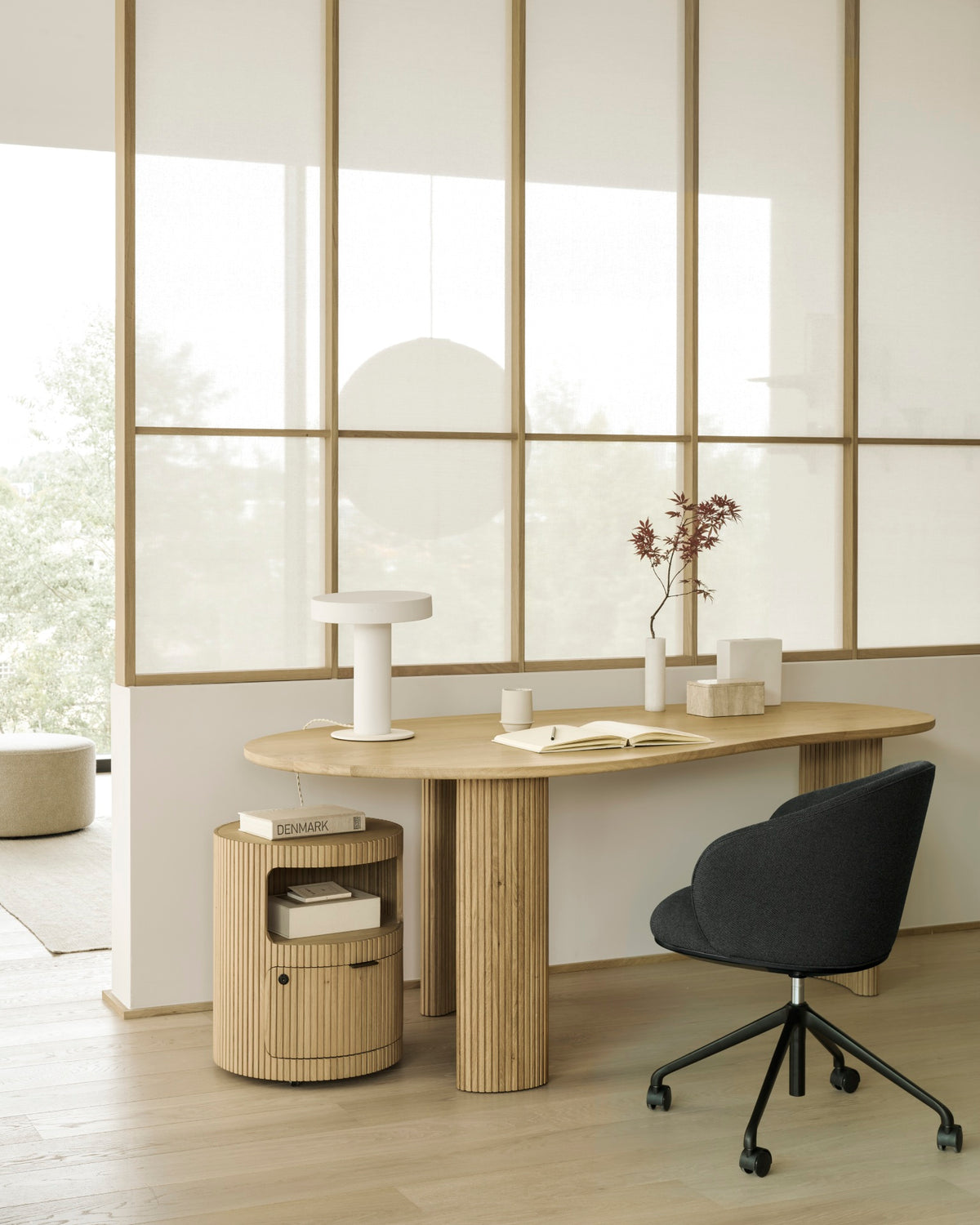 Ethnicraft UNDA office chair in Charcoal with casters at a desk in a modern home office.