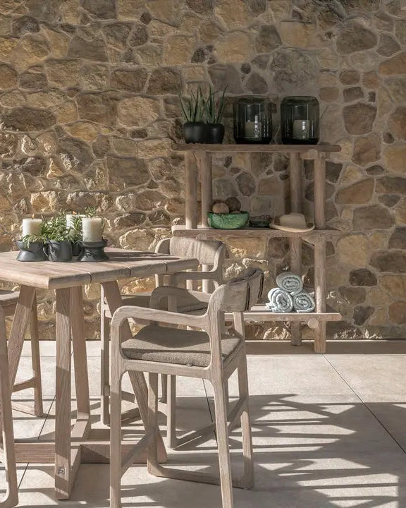 Gommaire SALLY bar chair in an outdoor lounge ambience - combined with bar table and green planting for stylish garden design with teak furniture