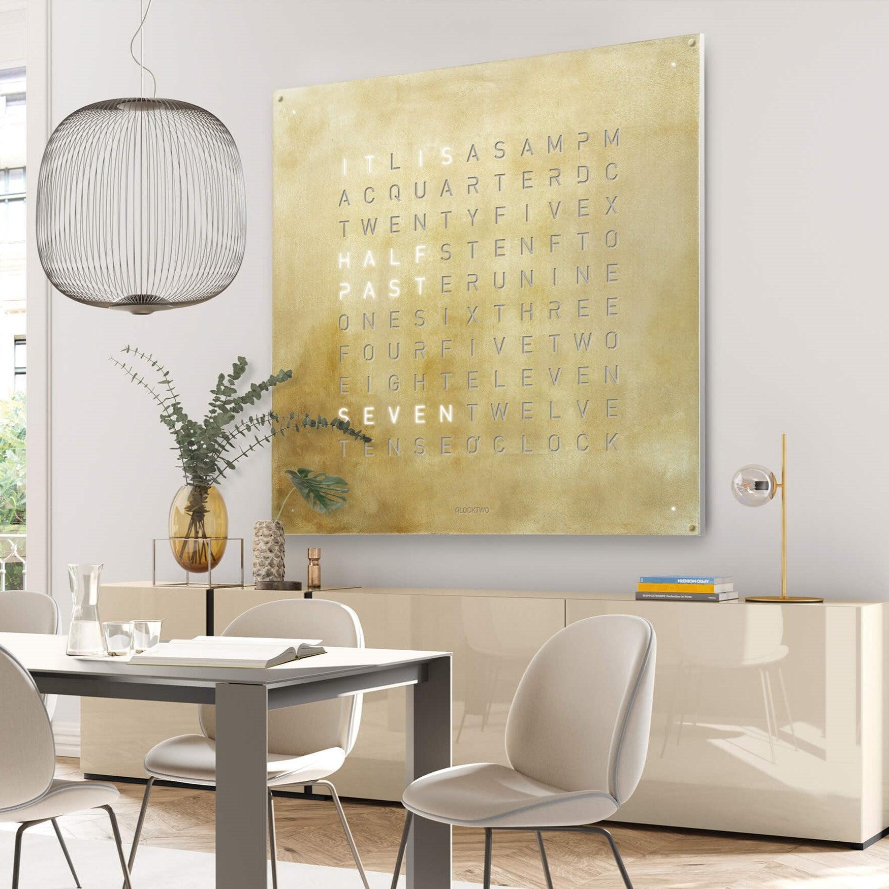 QLOCKTWO EARTH 180 SILVER & GOLD – exklusive Luxus-Wanduhr mit 180 cm Front aus gebürstetem Edelstahl und 24-Karat-Gold-Schriftbild. High-End Designuhr für moderne Architektur, Interior Design und Sammlerräume