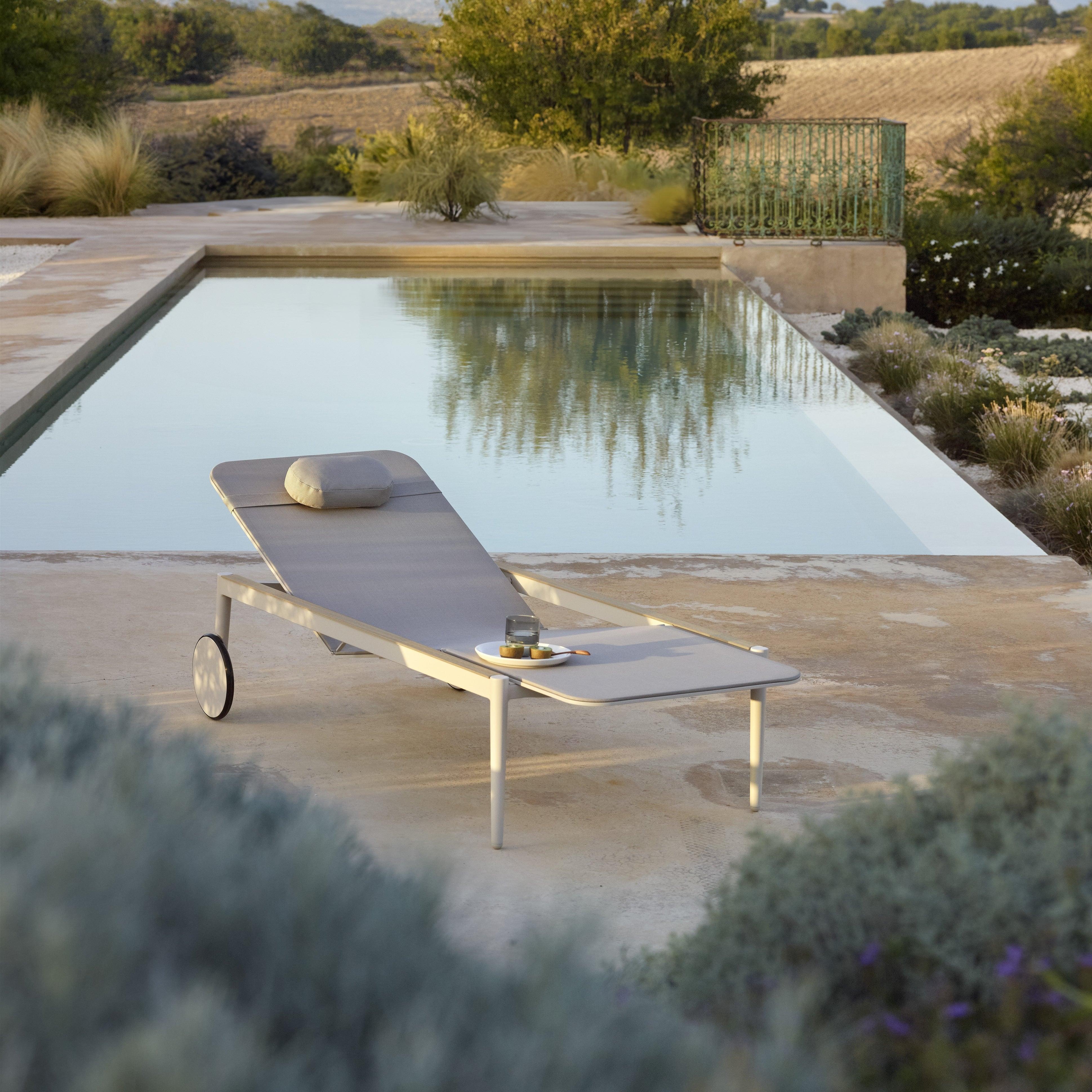 Royal Botania STYLETTO Sonnenliege in Weiß mit Teak-Armlehne – seitliche Poolansicht mit natürlicher Eleganz und Premium-Details