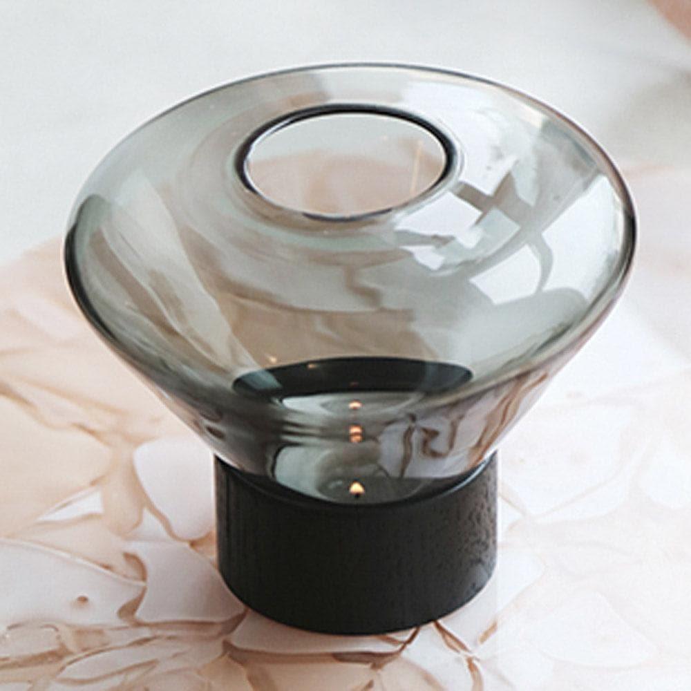 Windlicht MUFFIN von Brokis in Smoke Grey auf dem Boden platziert – dezente Beleuchtung für gemütliche Wohnbereiche