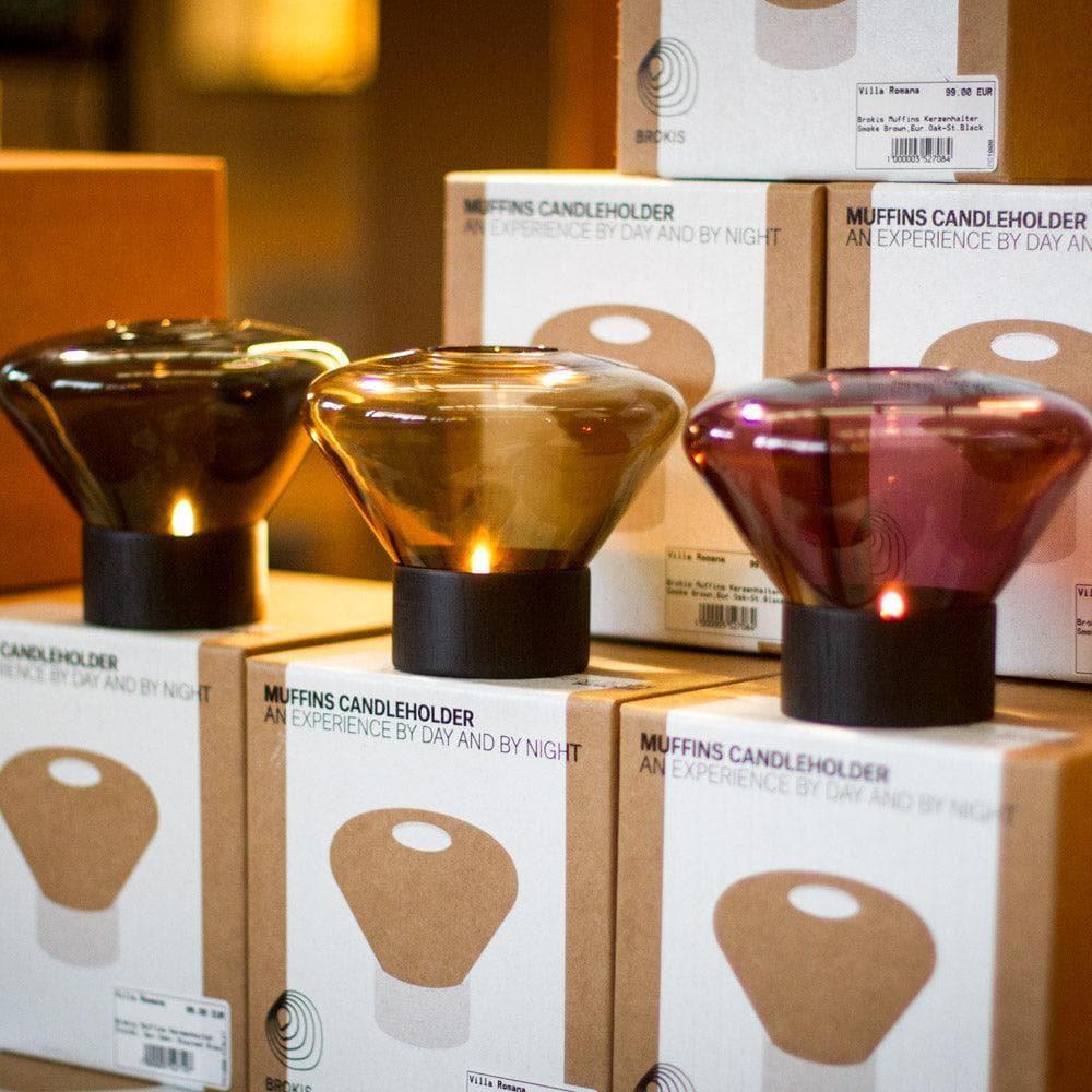 Präsentation mehrerer MUFFIN Windlichter von Brokis im Geschäft mit Originalverpackung – edles Design trifft auf hochwertige Inszenierung